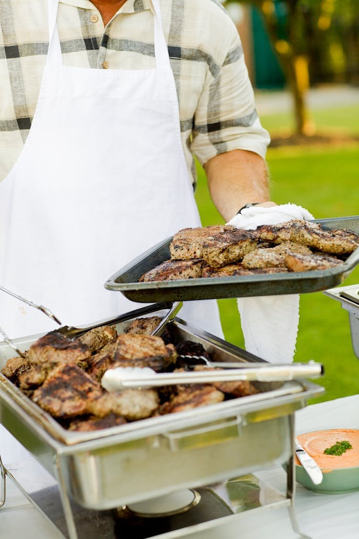 Deliciously grilled steaks being served outdoors at a barbecue event.